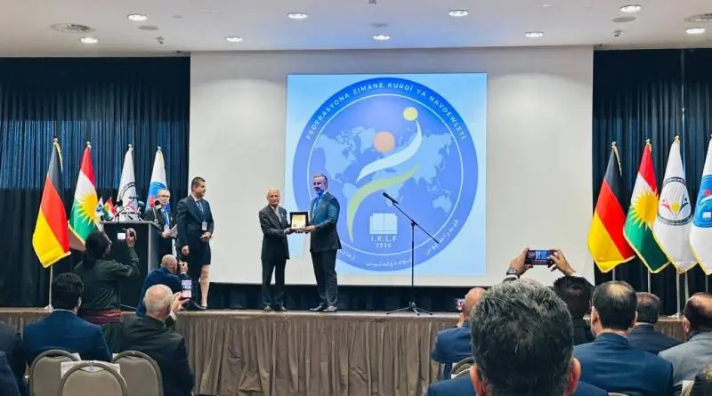 Bayram Ayaz, Kürt Diasporası Konfederasyonu Genel Temsilcisi Şifa Barzani'ye Kürt diline dair çalışmalarından dolayı plaket sundu
